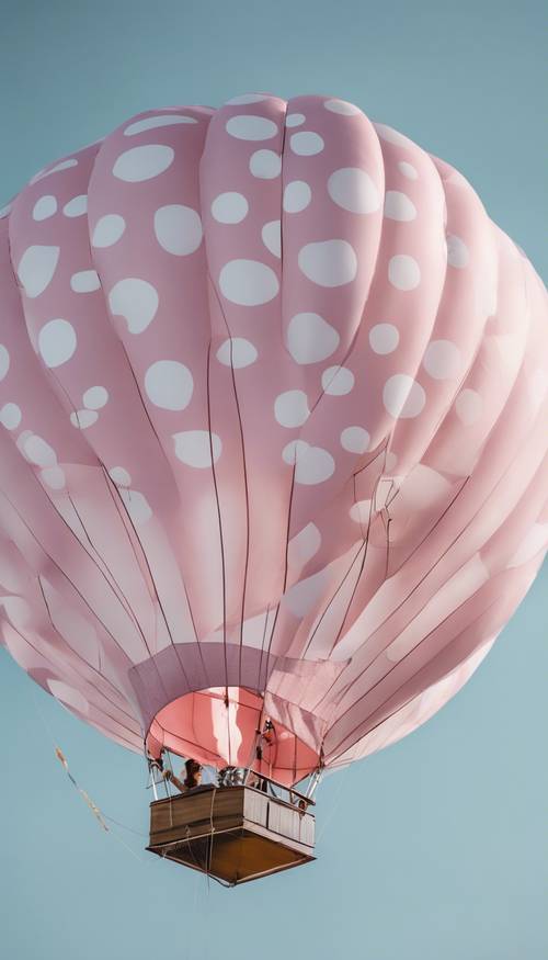 Um balão de ar quente de bolinhas rosa e branco voando no céu azul claro.