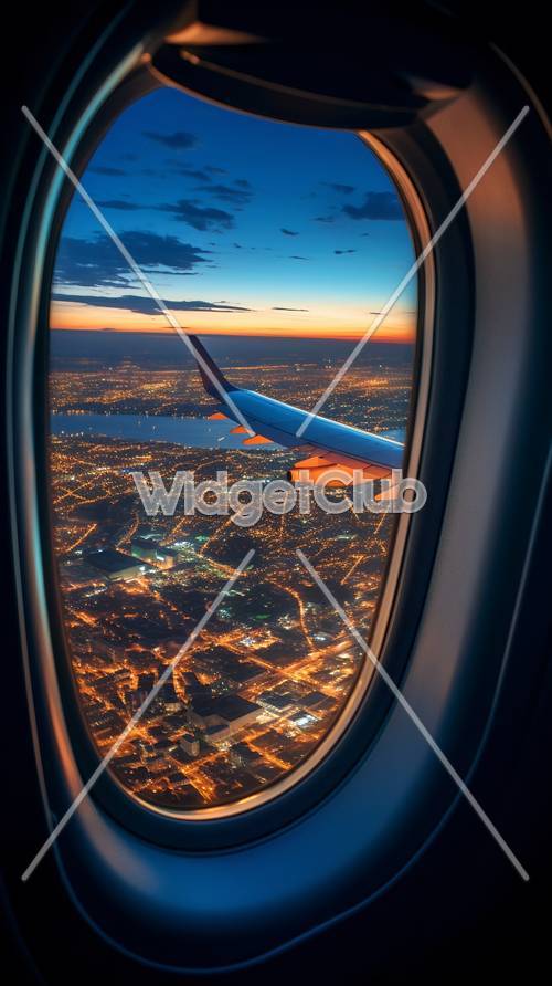 夕焼けの街を眺める飛行機の景色