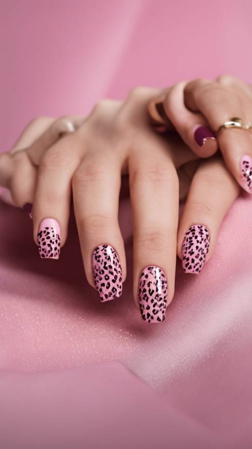 A woman's manicure with pink cheetah print nail design.