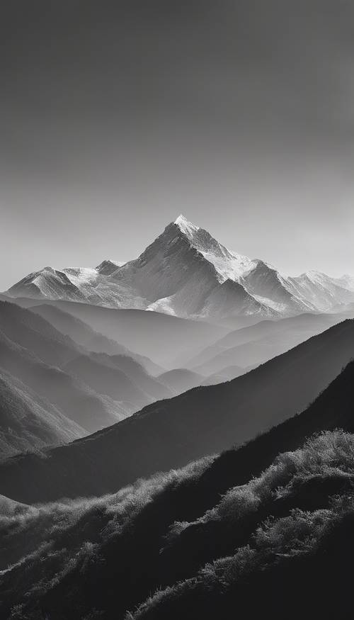 흑백 풍경 속에 산의 실루엣이 겹겹이 쌓여 있다.