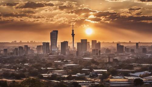 The golden sunset silhouette of Johannesburg city skyline.