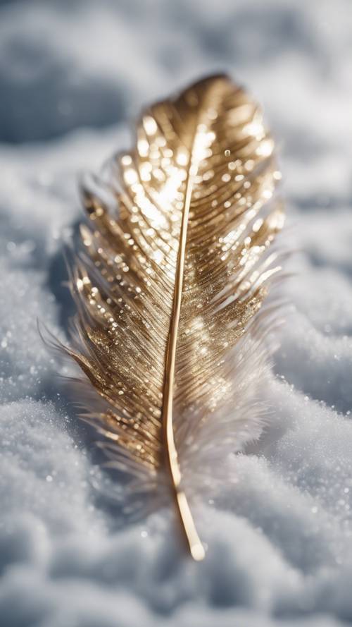 A delicate, gold glittery feather resting on a snowy surface