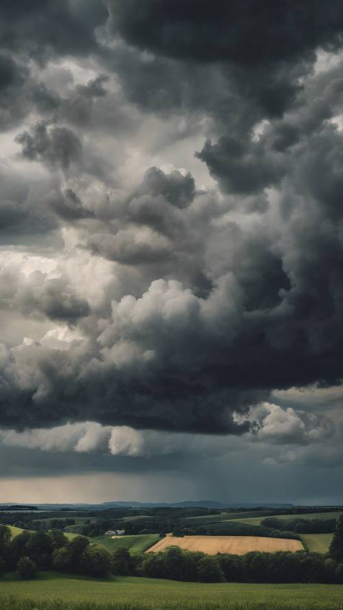 Un cielo tumultuoso lleno de oscuras nubes tormentosas que se ciernen sobre un tranquilo paisaje rural.