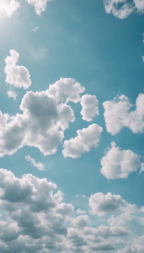 A group of happy puffy clouds in a light blue sky.
