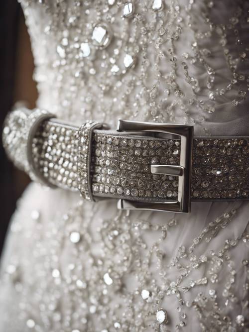 Um cinto cinza cravejado de diamantes acompanhando um elegante vestido branco.