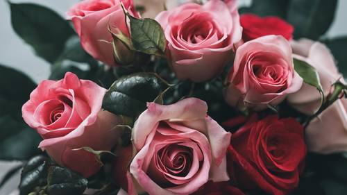 로맨틱한 레드와 핑크 장미가 하트 모양의 꽃다발에 얽혀 있습니다.