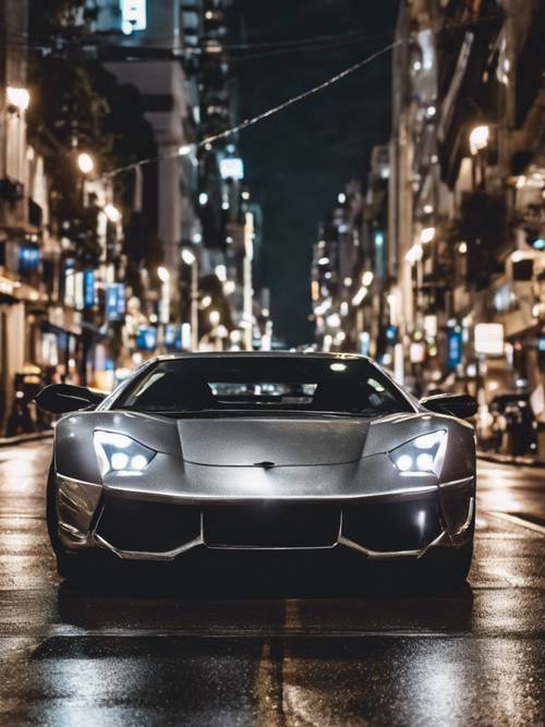 A silver metallic sports car zooming through the glistening streets of a city at night.