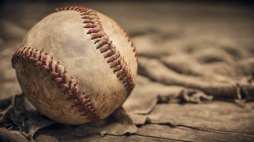 An old, well-worn baseball, its stitches frayed and leather faded, evoking nostalgia and countless stories.