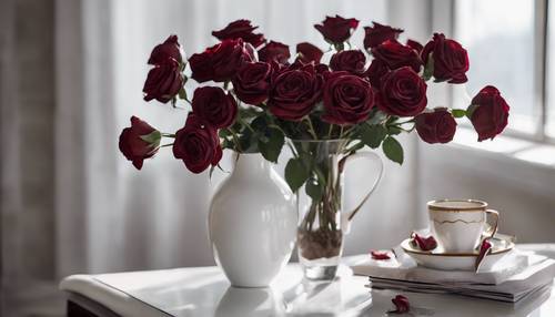 Selusin mawar beludru berwarna merah marun dipajang dalam vas porselen putih mengkilap di atas meja kopi kaca